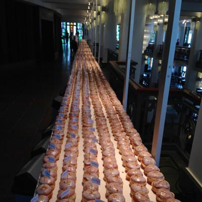 A factory-like conveyor belt lined with donuts